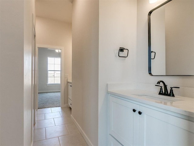 bathroom featuring baseboards, tile patterned floors, and vanity