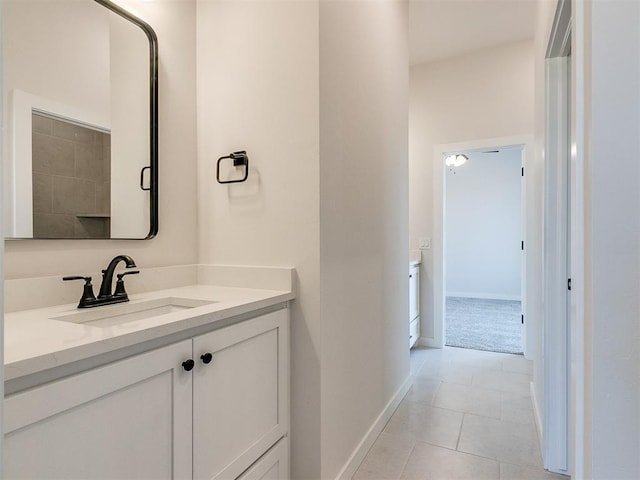 bathroom with baseboards, tile patterned floors, and vanity