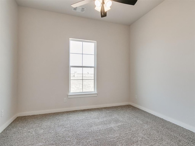 carpeted spare room with baseboards, visible vents, and a ceiling fan