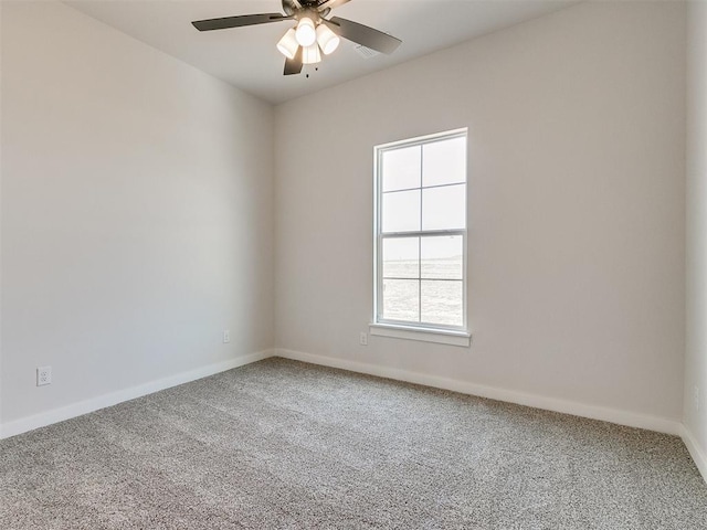 carpeted empty room featuring a ceiling fan and baseboards