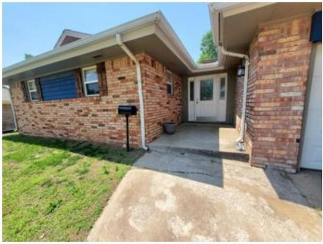 1313 Kingston Dr, Yukon, OK 73099 - exterior space featuring a yard and brick siding