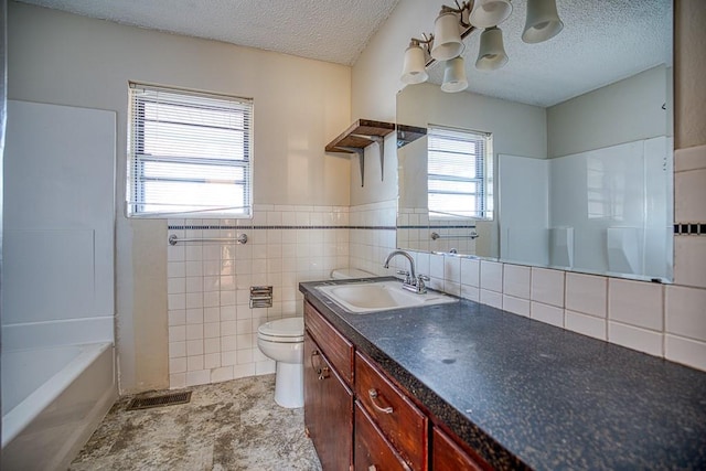 834 Mimosa Dr, Watonga, OK 73772 - full bathroom featuring tile walls, a textured ceiling, toilet, and a notable chandelier