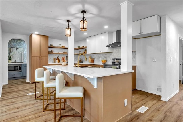 636 E Lea Ter, Mustang, OK 73064 - kitchen featuring stainless steel appliances, wall chimney range hood, a sink, open shelves, and backsplash