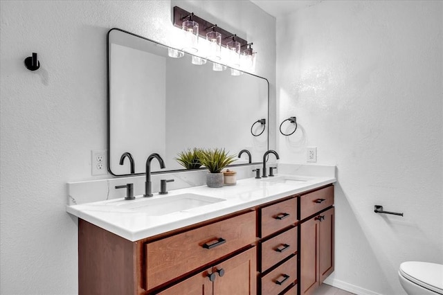 636 E Lea Ter, Mustang, OK 73064 - full bathroom featuring double vanity, toilet, and a textured wall