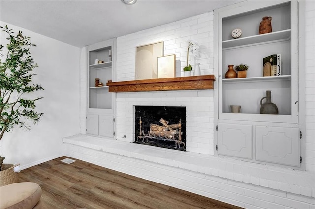 636 E Lea Ter, Mustang, OK 73064 - living room featuring built in features, dark wood-style flooring, a fireplace, and baseboards