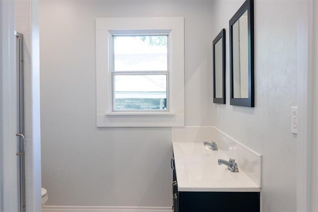bathroom with a shower stall, vanity, plenty of natural light, and toilet