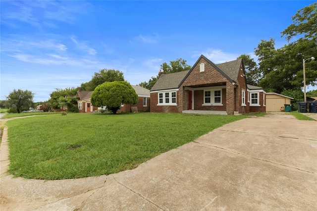 view of front of property featuring concrete driveway, roof with shingles, brick siding, and a front lawn