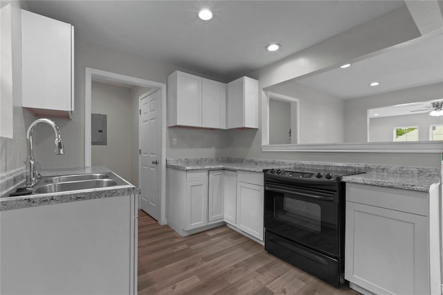 kitchen featuring white cabinets, a sink, ceiling fan, black electric range oven, and light wood-style floors