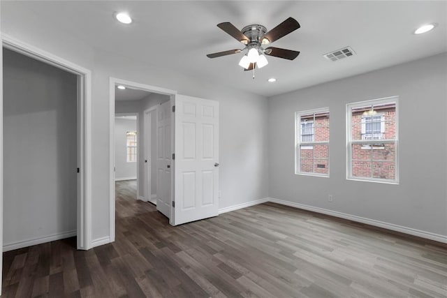 unfurnished bedroom featuring visible vents, recessed lighting, multiple windows, and wood finished floors