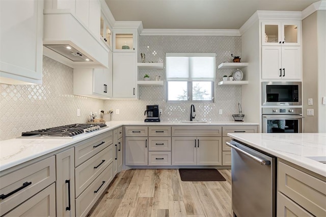 kitchen with a sink, open shelves, appliances with stainless steel finishes, and ornamental molding