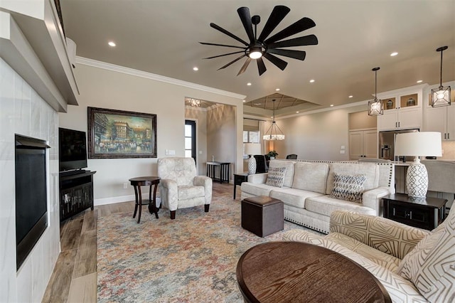 living room with baseboards, light wood-type flooring, ornamental molding, recessed lighting, and ceiling fan