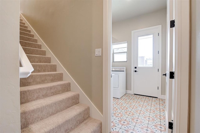 entrance foyer featuring washer / clothes dryer, baseboards, stairway, and light floors