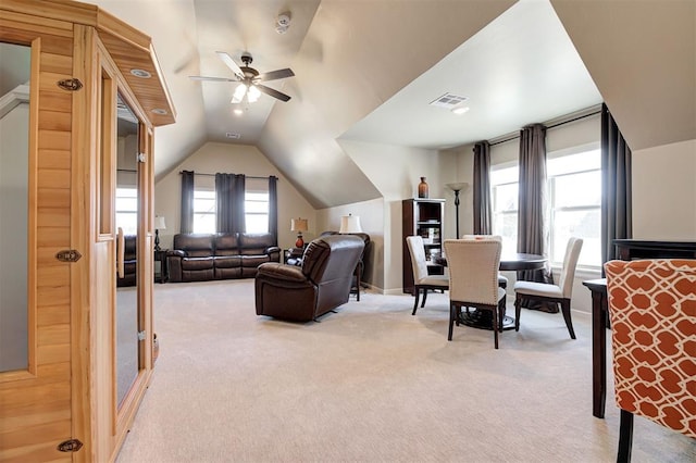 carpeted living area with visible vents, a ceiling fan, and vaulted ceiling