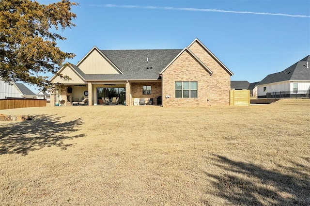back of property featuring a patio area, a yard, and fence