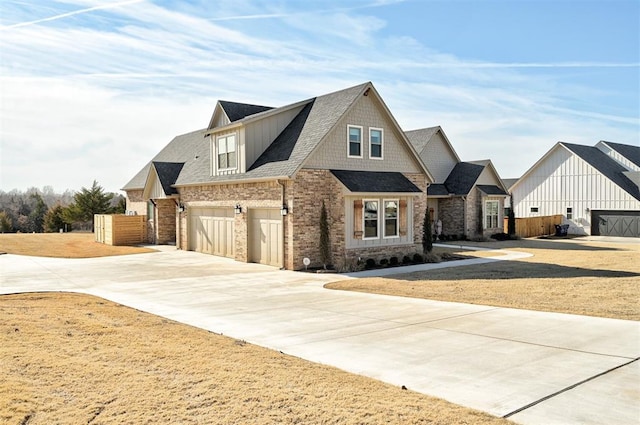 view of front of house featuring an attached garage, driveway, fence, and a shingled roof