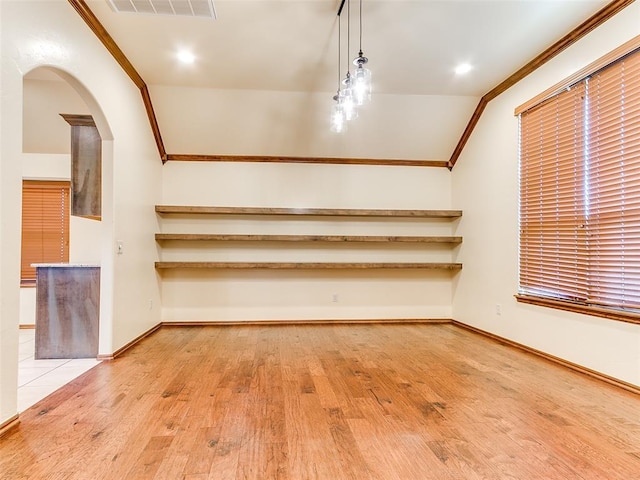 interior space with arched walkways, visible vents, crown molding, and wood finished floors