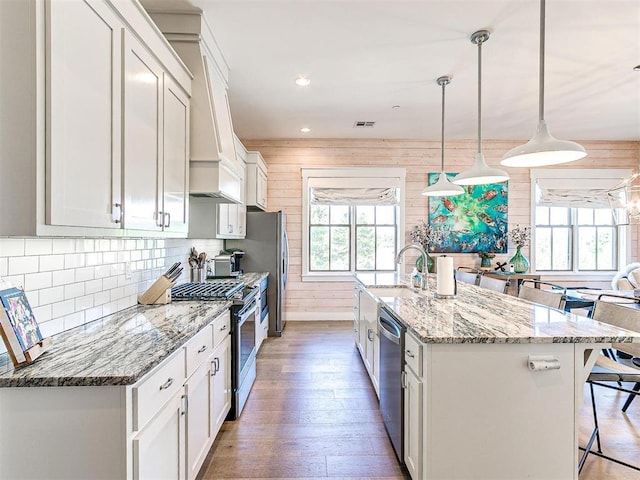 29 Water St Unit 10G, Carlton Landing, OK 74432 - kitchen featuring a wealth of natural light, wood walls, a kitchen breakfast bar, and stainless steel appliances