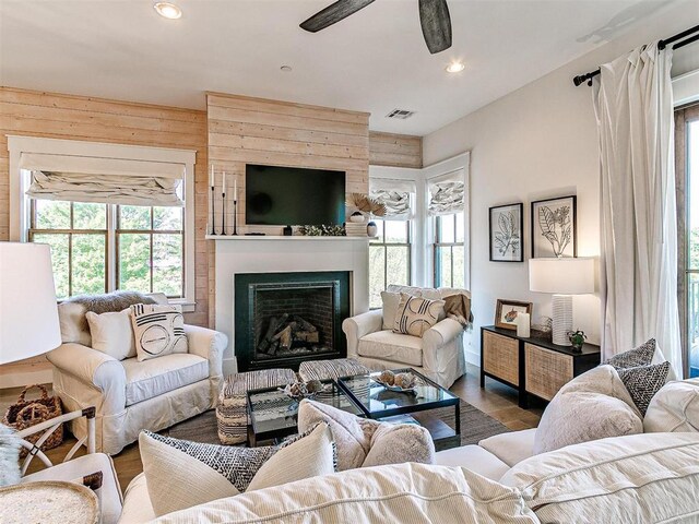 29 Water St Unit 10G, Carlton Landing, OK 74432 - living area with visible vents, a ceiling fan, a fireplace, wooden walls, and wood finished floors