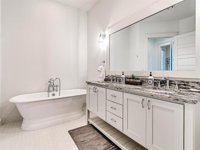 29 Water St Unit 10G, Carlton Landing, OK 74432 - bathroom featuring a soaking tub, double vanity, a sink, and baseboards