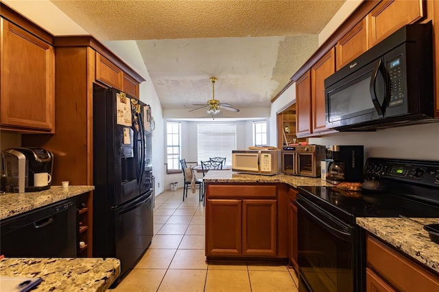 kitchen featuring lofted ceiling, light tile patterned floors, a textured ceiling, black appliances, and a peninsula