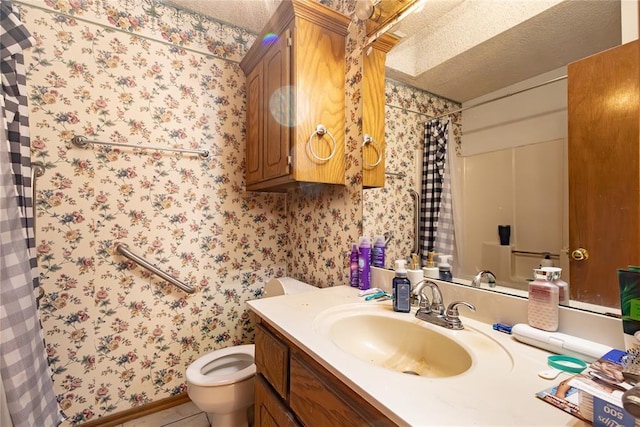 bathroom featuring toilet, wallpapered walls, and vanity