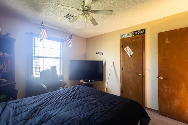 carpeted bedroom with a ceiling fan and a textured ceiling