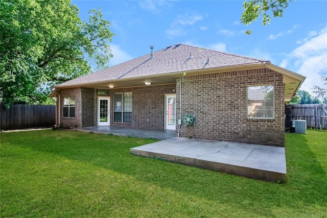 1417 Mayer Dr, Yukon, OK 73099 - back of property featuring a fenced backyard, a patio area, brick siding, and roof with shingles