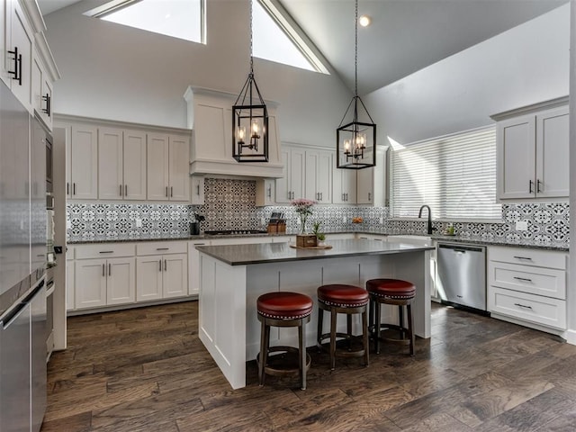 kitchen with dishwasher, hanging light fixtures, dark wood-style floors, a kitchen breakfast bar, and a notable chandelier
