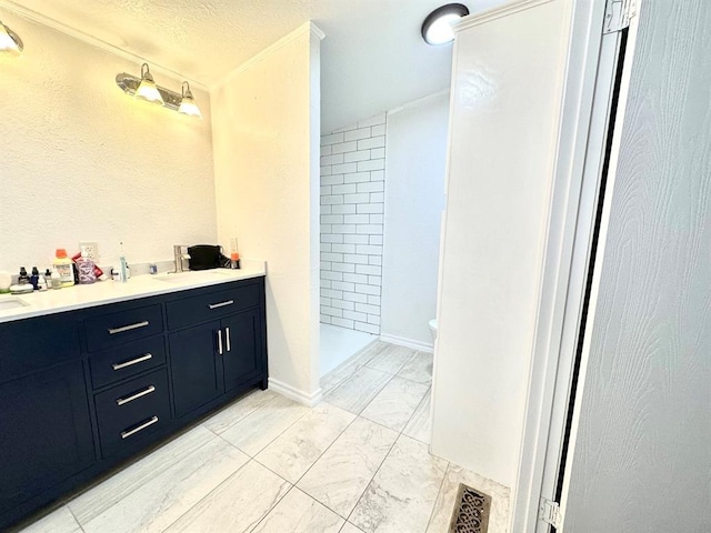full bathroom with a shower stall, a textured ceiling, marble finish floor, visible vents, and double vanity