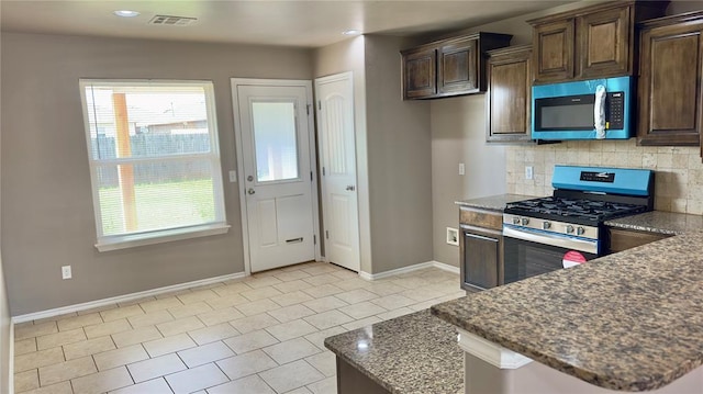 kitchen with baseboards, a wealth of natural light, appliances with stainless steel finishes, and decorative backsplash