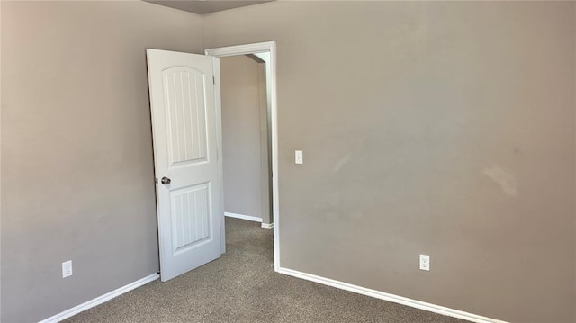 unfurnished room with baseboards and carpet floors