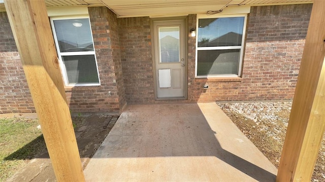 doorway to property featuring brick siding