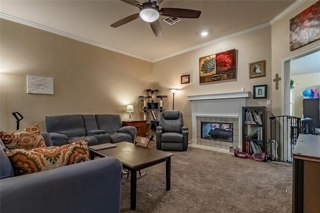 carpeted living area with ornamental molding, a ceiling fan, visible vents, and a fireplace