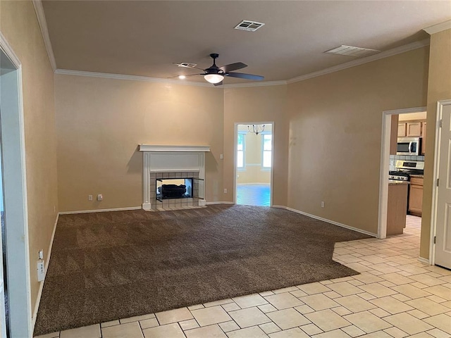 17413 Platinum Ln, Edmond, OK 73012 - unfurnished living room with a ceiling fan, ornamental molding, a fireplace, light colored carpet, and baseboards
