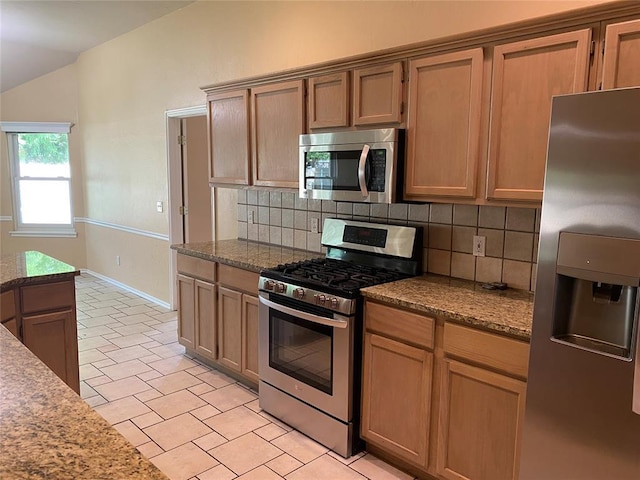17413 Platinum Ln, Edmond, OK 73012 - kitchen with stainless steel appliances, backsplash, vaulted ceiling, baseboards, and dark stone counters