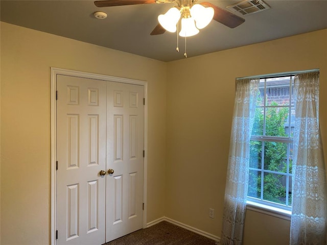 17413 Platinum Ln, Edmond, OK 73012 - unfurnished bedroom with multiple windows, dark colored carpet, a closet, and baseboards