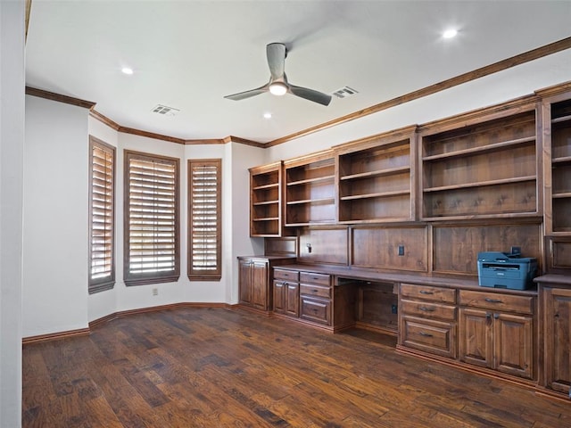 unfurnished office with dark wood-style floors, built in desk, baseboards, and a ceiling fan