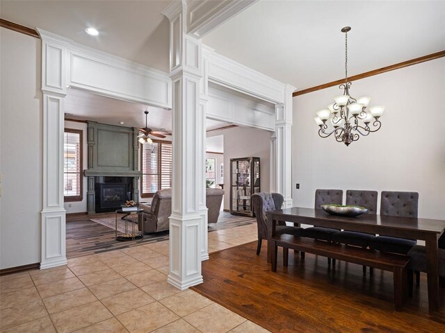 dining area with a large fireplace, decorative columns, and light tile patterned flooring