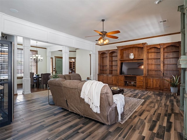 living room with decorative columns, dark wood-type flooring, visible vents, and ceiling fan with notable chandelier