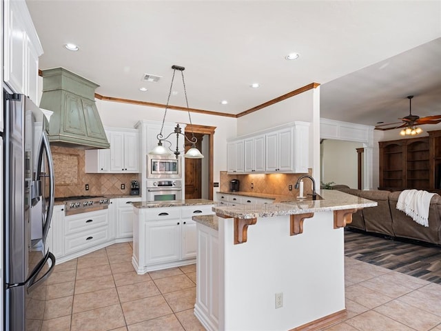 kitchen with stainless steel appliances, light tile patterned floors, open floor plan, and a peninsula