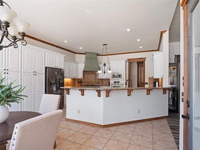 kitchen featuring a kitchen bar, crown molding, decorative backsplash, and stainless steel appliances