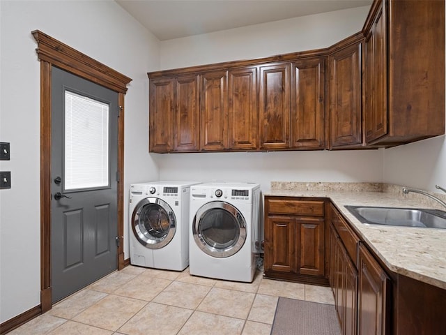 laundry room with light tile patterned floors, washing machine and dryer, a sink, and cabinet space