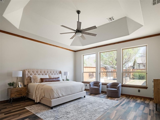 bedroom featuring visible vents, multiple windows, and wood finished floors