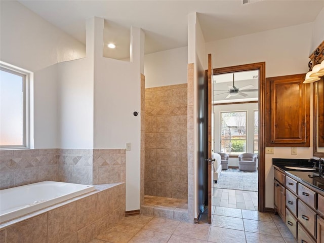 bathroom with a ceiling fan, a walk in shower, vanity, tile patterned floors, and a garden tub