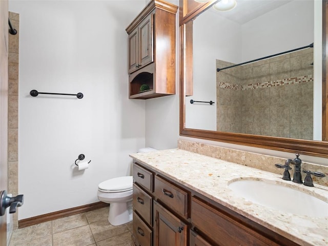 bathroom featuring vanity, toilet, walk in shower, tile patterned floors, and baseboards