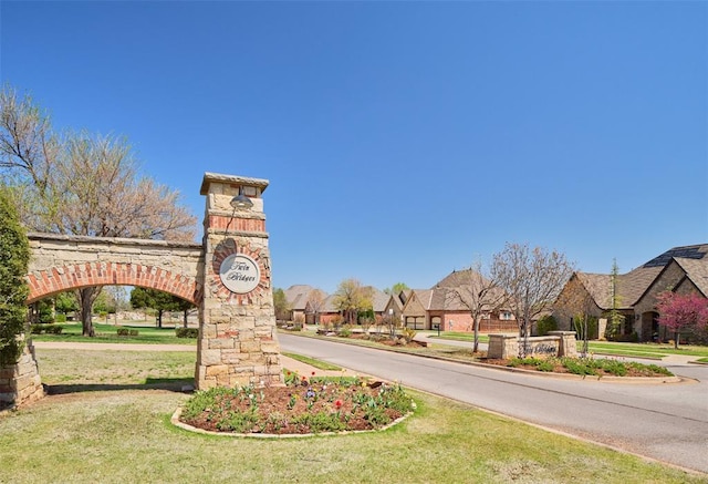 community / neighborhood sign with a yard and a residential view