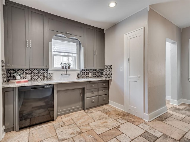 1016 E Edwards St, Edmond, OK 73034 - kitchen featuring gray cabinets, backsplash, stone tile flooring, black dishwasher, and baseboards