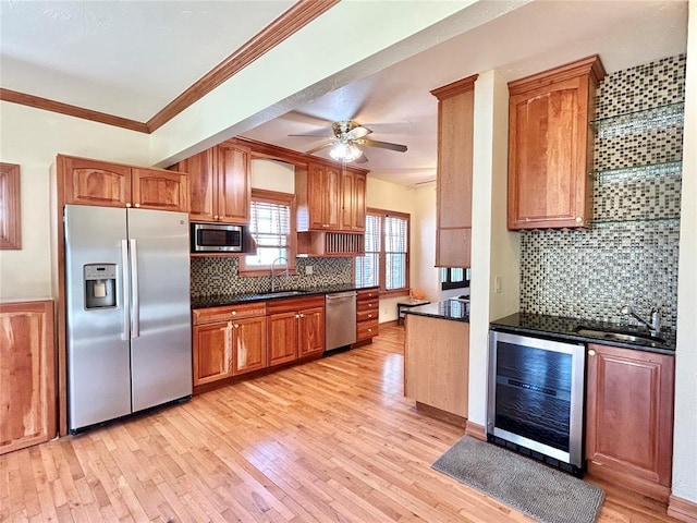 1909 N Gatewood Ave, Oklahoma City, OK 73106 - kitchen featuring dark countertops, light wood-style floors, stainless steel appliances, beverage cooler, and a sink