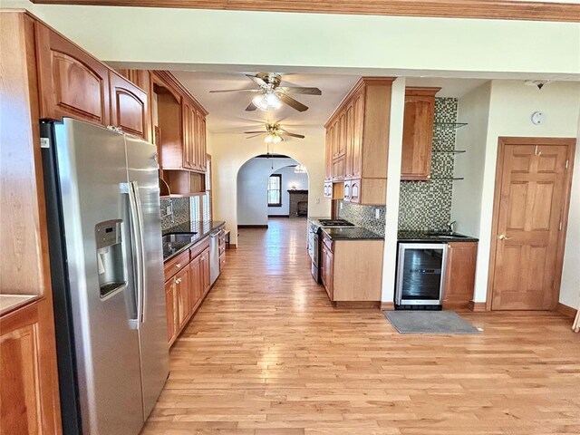 1909 N Gatewood Ave, Oklahoma City, OK 73106 - kitchen with arched walkways, a ceiling fan, light wood-style floors, wine cooler, and stainless steel appliances