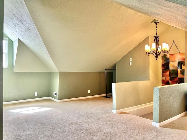 1909 N Gatewood Ave, Oklahoma City, OK 73106 - additional living space with carpet floors, a notable chandelier, visible vents, and a textured ceiling
